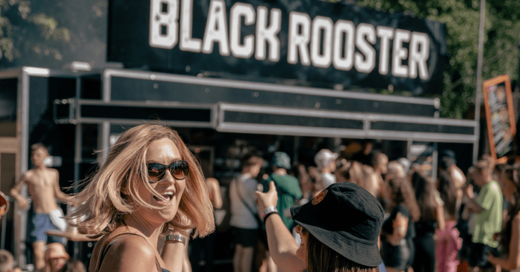Crowd enjoying the Black Rooster Peri Peri experience at TRNSMT Glasgow, with fans soaking up the festival atmosphere in front of the Black Rooster food truck - also a regular at Rangers Football Club’s Ibrox Stadium.